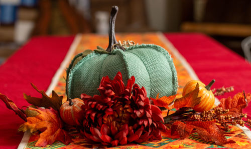 A handmade pumpkin decoration surrounded by decorative fall foliage, laid out for the autumn season.