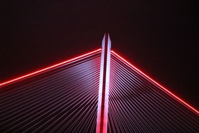 Low angle view of suspension bridge against sky at night