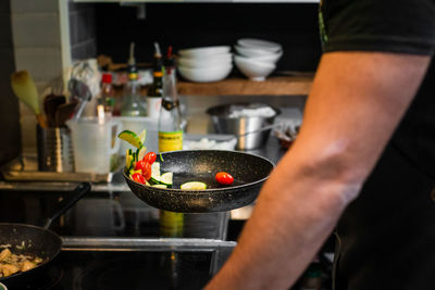 Midsection of man preparing food in kitchen