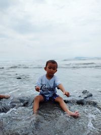 Full length of cute boy enjoying in sea