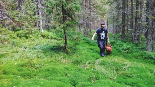 Full length of man standing on land in forest