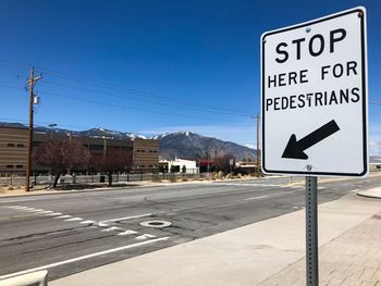 Road sign against clear blue sky