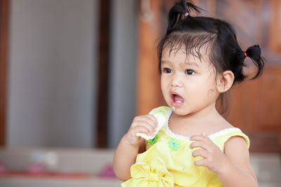 Close-up of cute baby girl eating fruit