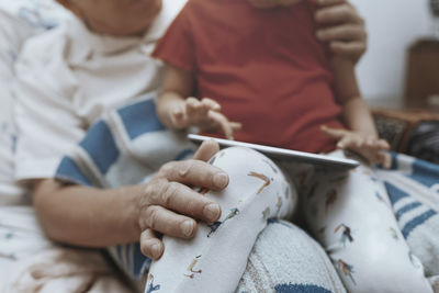 Grandfather and granddaughter digital tablet, close-up