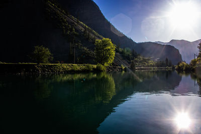 Scenic view of lake by mountains against sky