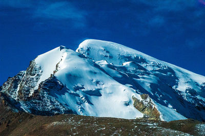 Scenic view of snowcapped mountain against blue sky