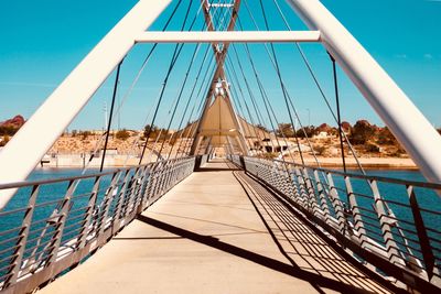 View of footbridge against blue sky