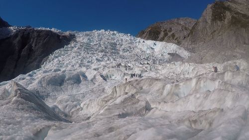 Low angle view of glacier on mountain against sky
