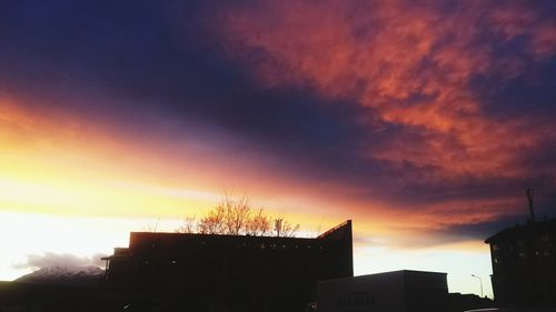 Low angle view of silhouette buildings against dramatic sky