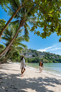 Rear view of people walking on beach