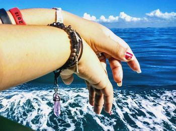 Low section of man in sea against sky