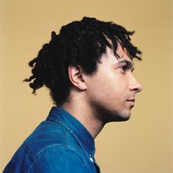 Portrait of young man looking away against gray background