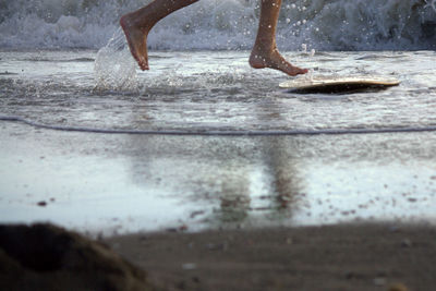 Low section of woman on wet beach