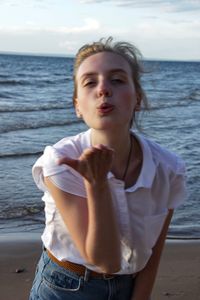 Portrait of beautiful young woman standing on beach