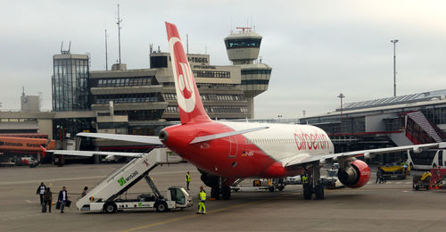 Airplane on airport runway against sky