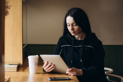 Young woman using mobile phone at home