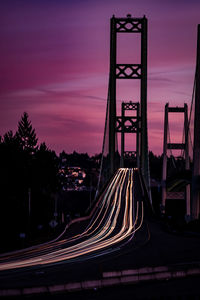 Light trails on road against sky at sunset