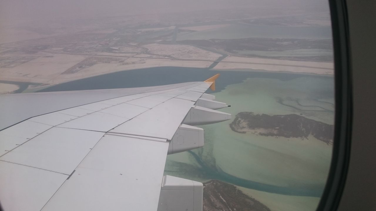 LOW ANGLE VIEW OF AIRPLANE WING OVER SEA