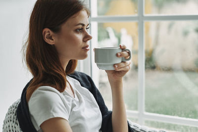 Close-up of woman looking through window