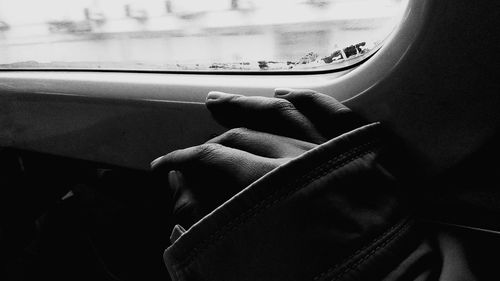 Cropped hand by window in car