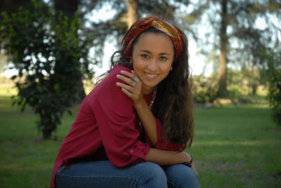 Portrait of a smiling young woman sitting outdoors