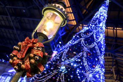 Low angle view of illuminated lighting equipment hanging on ceiling