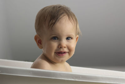 Portrait of baby smiling in bathtub