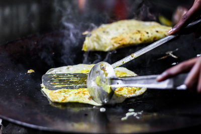 Cropped image of person preparing food on barbecue grill