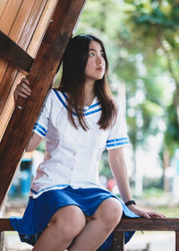 Young woman sitting on wood
