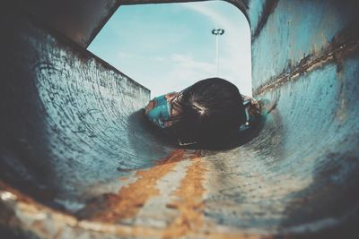 Woman lying down in rusty slide