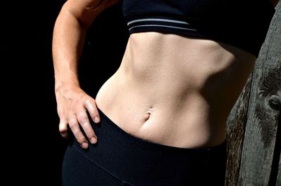 Midsection of woman with sweaty abdomen