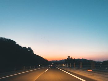 Road against clear sky at sunset