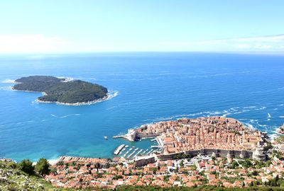 High angle view of townscape by sea against sky
