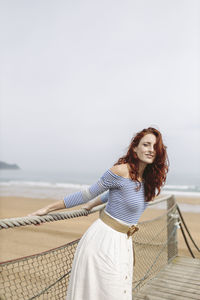 Woman holding rope while standing on pier