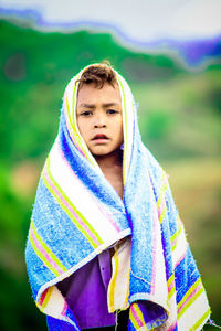 Portrait of boy wearing towel while standing outdoors