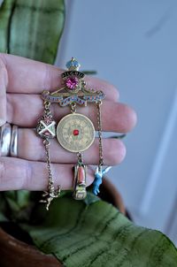 Cropped hand of person holding jewelry at home