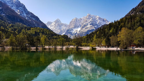 Jasna lake in slovenia, mountains and trees reflected in the clear water, snowy, autumn, travel