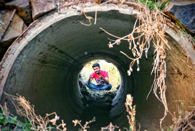 Rear view of man sitting in tunnel