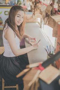 Portrait of smiling young woman sitting in store