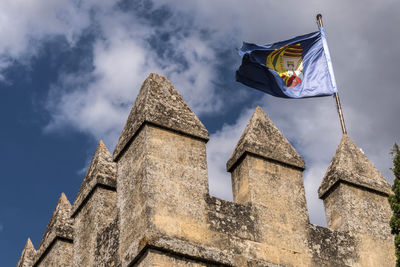 Low angle view of flags on building against sky