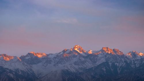 Scenic view of snowcapped mountains against sky during sunset