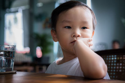 Close-up of cute boy sitting on chair at home