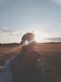 Man on field against sky during sunset