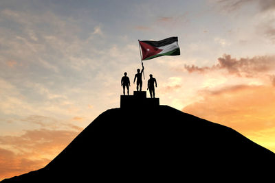 Low angle view of silhouette people standing against sky during sunset