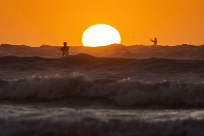 People kiteboarding on sea against sky