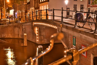 View of bridge over canal in city at night