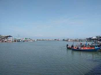 Fishing boats in sea against sky