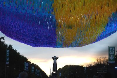 Low angle view of illuminated lanterns hanging against sky