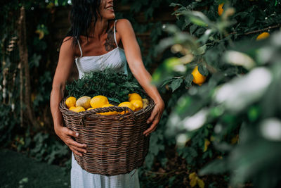 Young woman holding fruits in basket