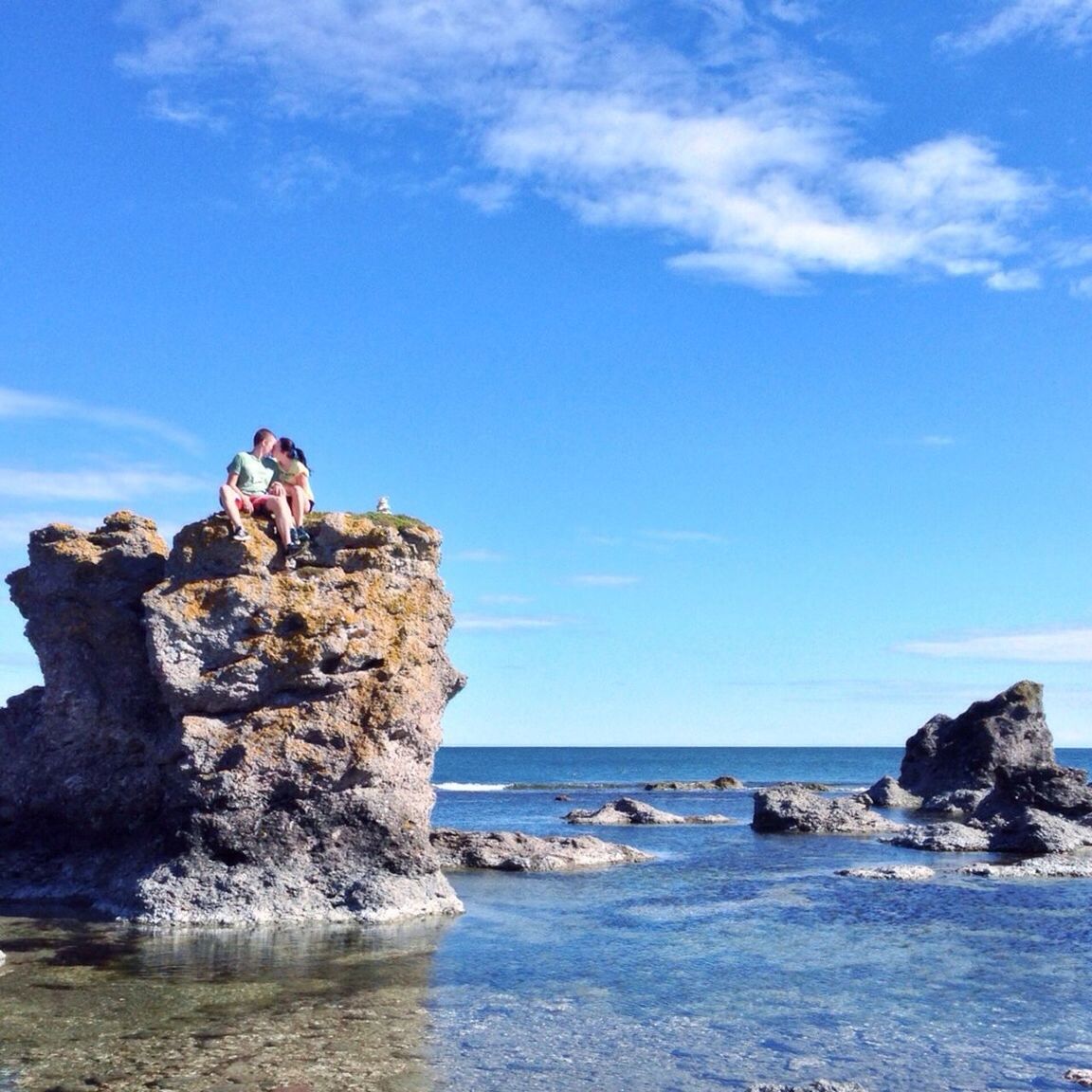 sea, water, horizon over water, rock - object, sky, leisure activity, lifestyles, rock formation, beach, blue, vacations, beauty in nature, nature, scenics, cliff, tranquility, shore, person